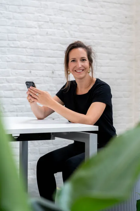 medewerker-van-GBL-lacht-met-gsm-in-hand